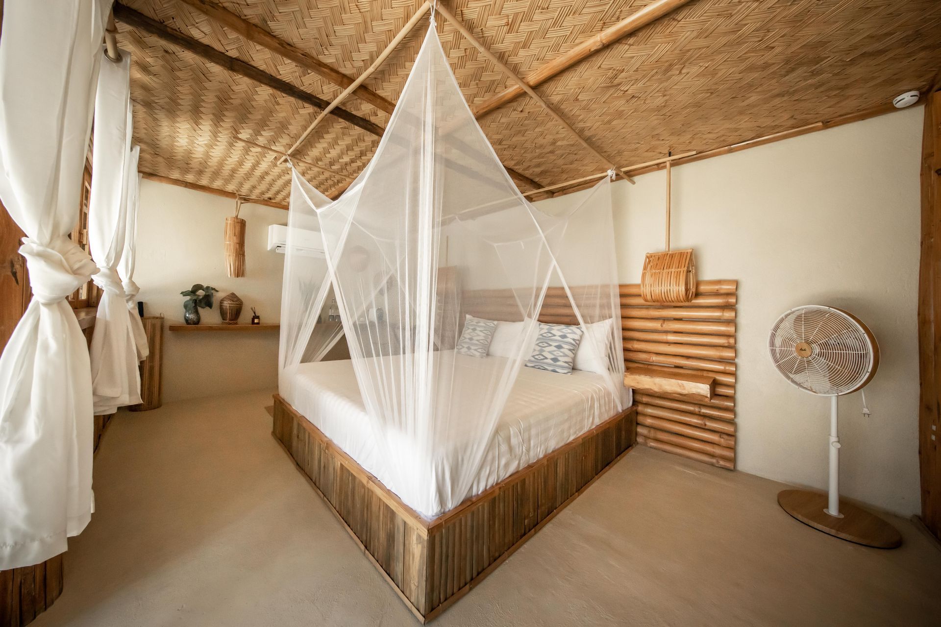 A bedroom with a canopy bed and a fan.