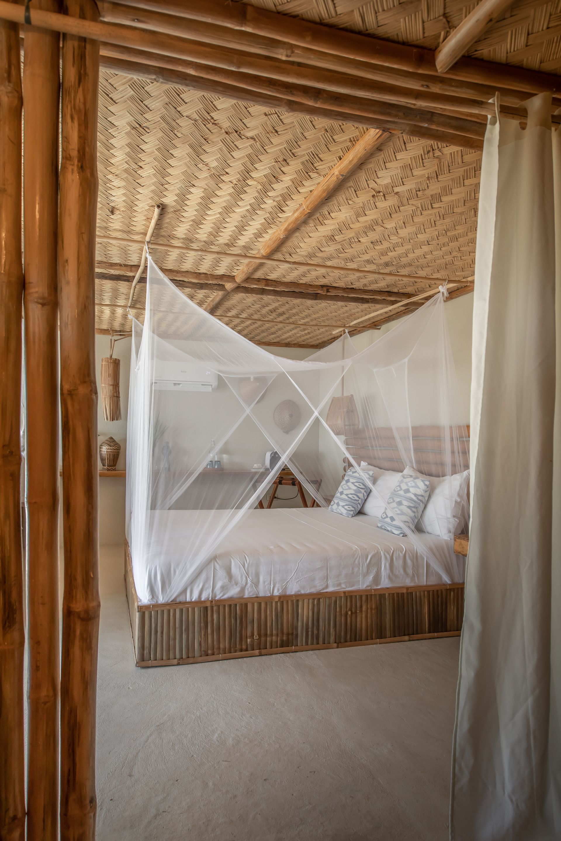 A bedroom with a canopy bed and a mosquito net.