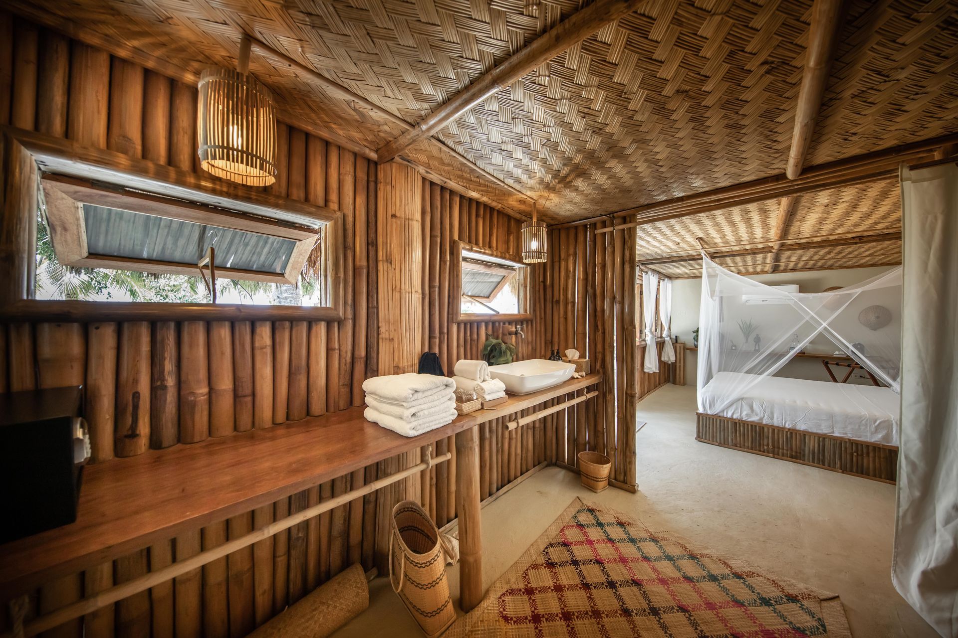 A bathroom in a wooden hut with a sink and a bed.