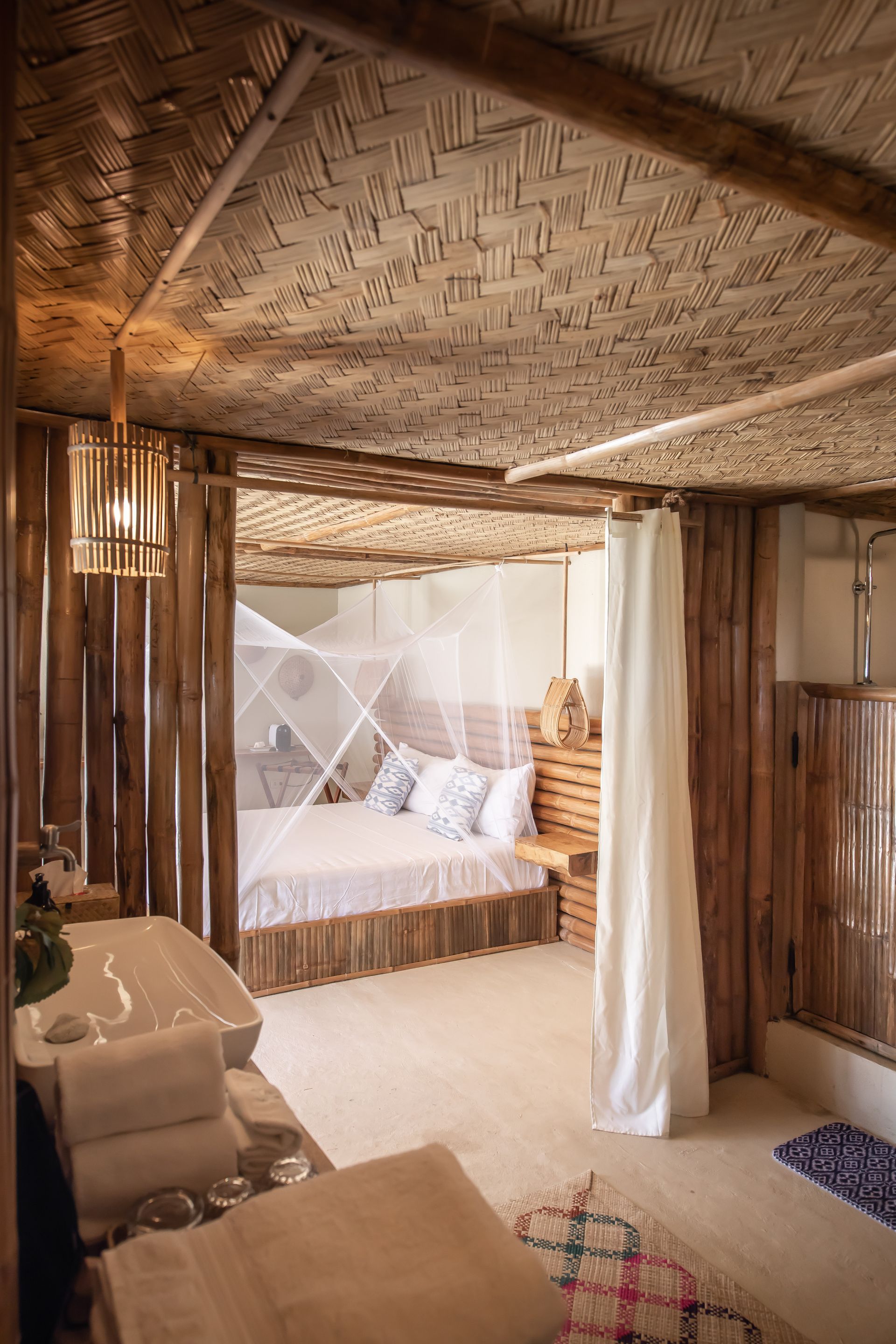 A bedroom with a bed , sink , and shower.