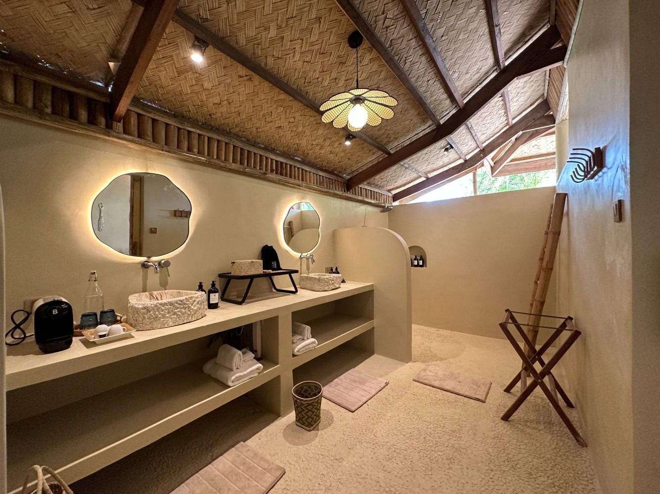 A bathroom with two sinks , two mirrors and a ladder.