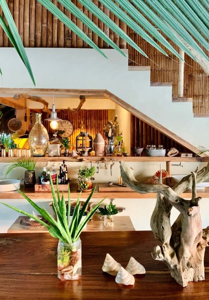 A wooden table with plants and a statue on it in a kitchen.
