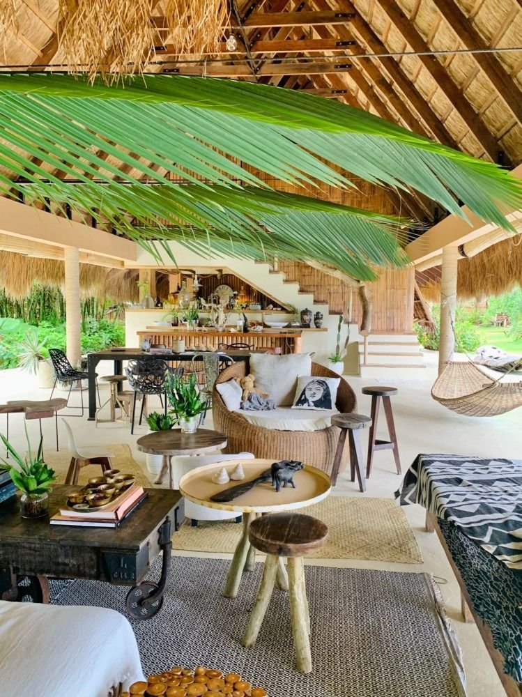 A living room filled with furniture and a thatched roof.