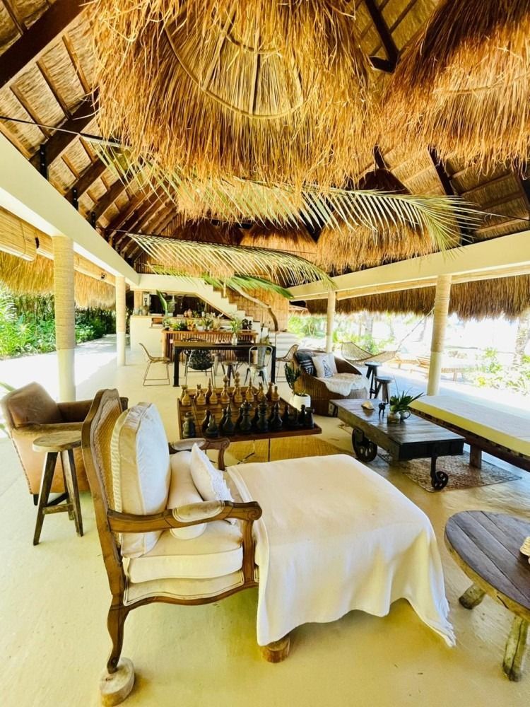 A large room with a lot of furniture and a thatched roof.