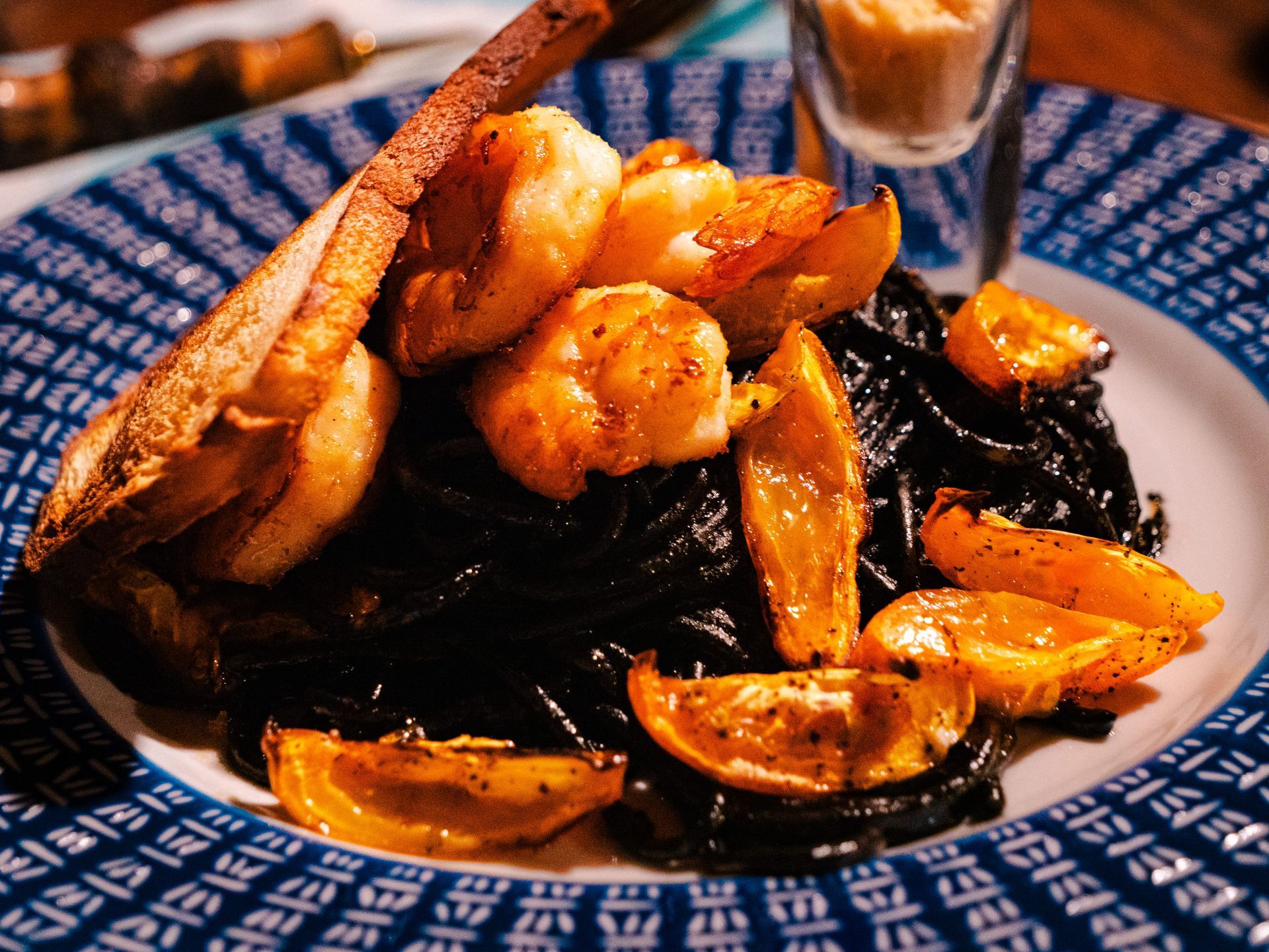 A plate of food with shrimp and bread on a table.