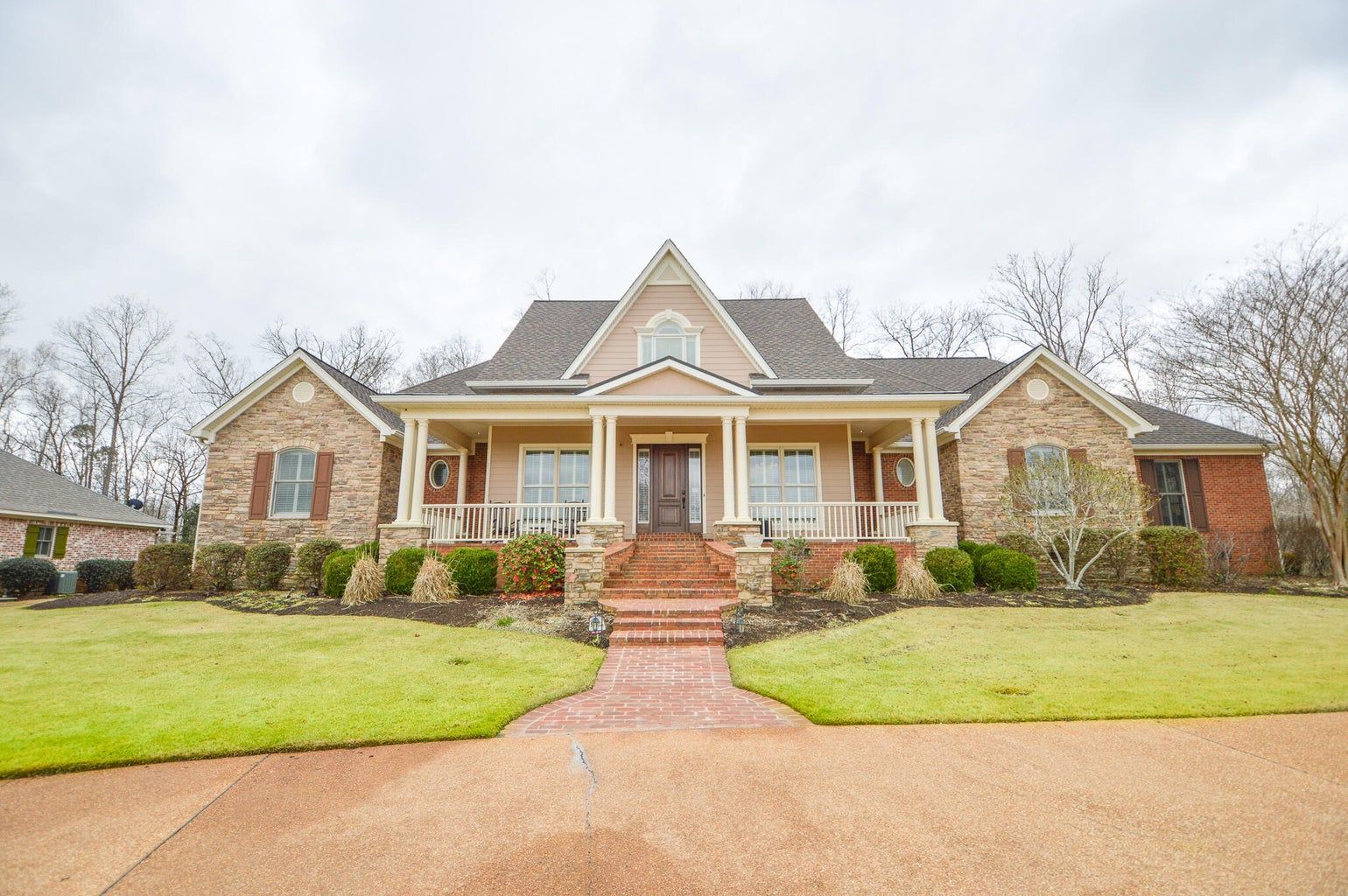 a large brick house with a porch and stairs