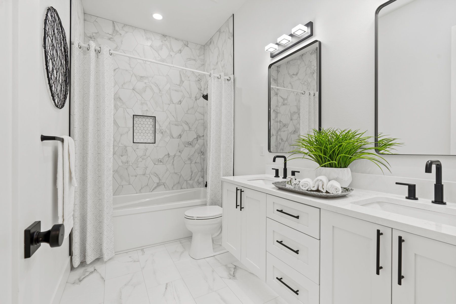 A bathroom with two sinks , a toilet , and a bathtub.