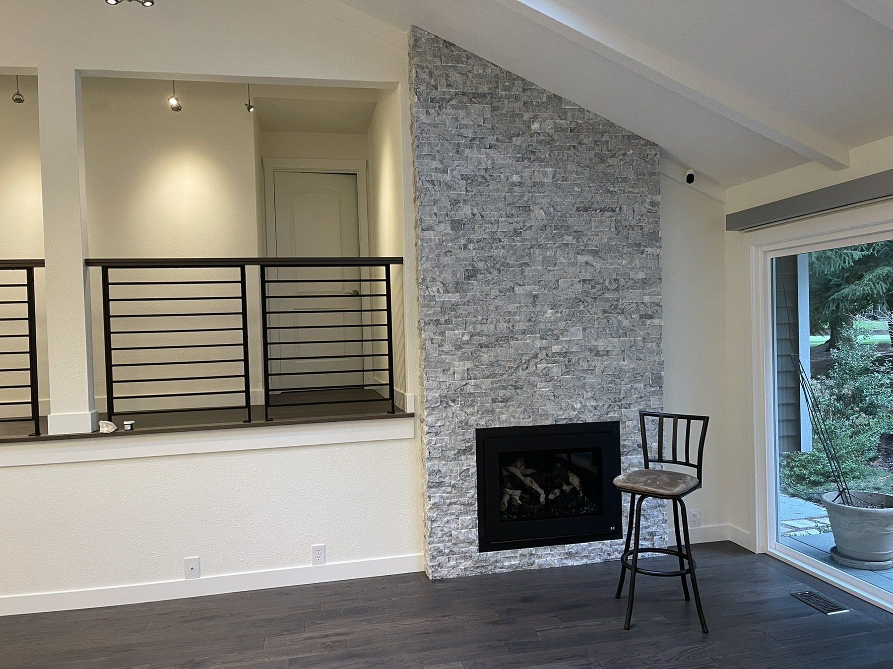 An empty living room with a fireplace and a chair.