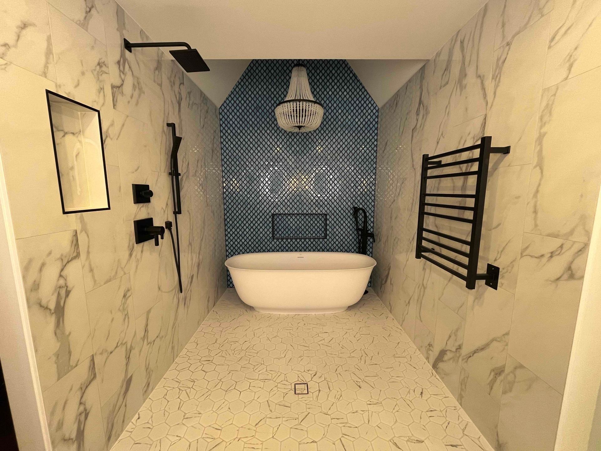 A bathroom with a bathtub , shower , mirror and towel rack.