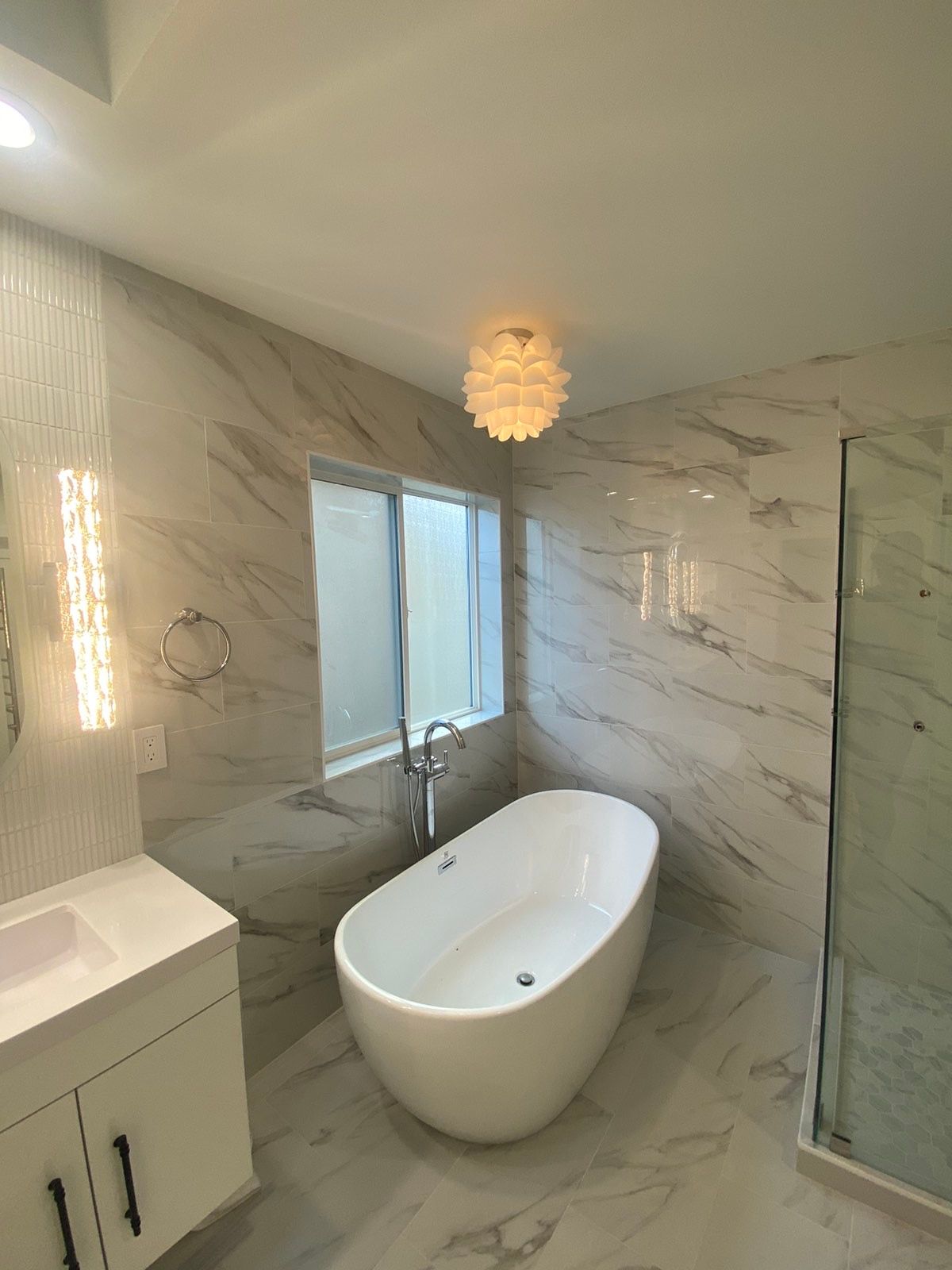 A bathroom with a bathtub , sink , and shower.
