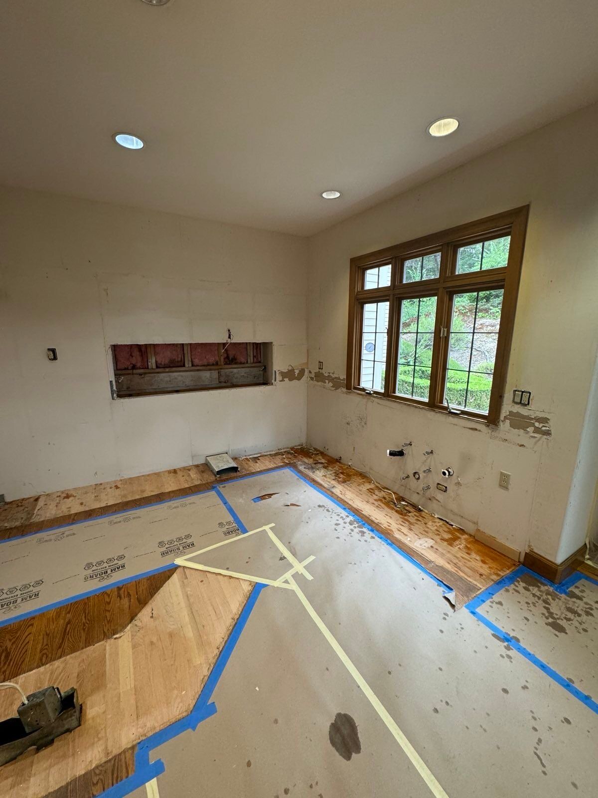 A room with a lot of windows and a lot of tape on the floor.