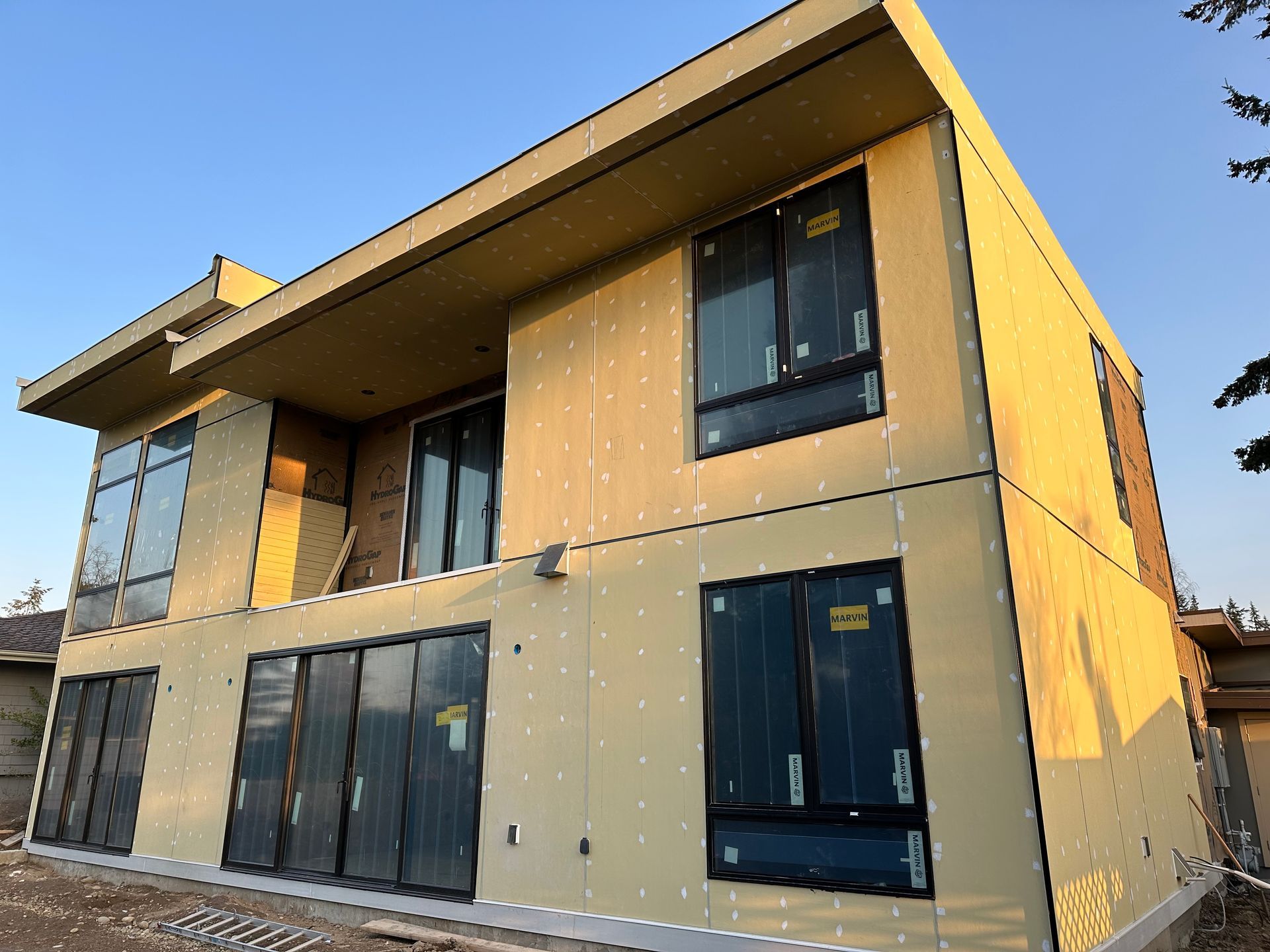 A large house with a lot of windows is being built.
