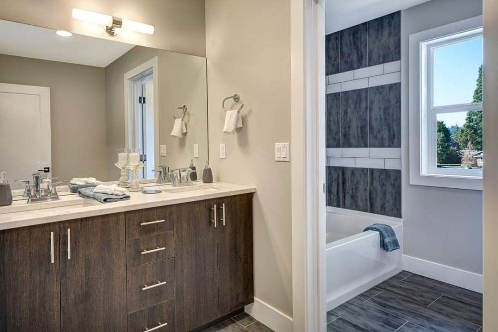 A bathroom with two sinks , a mirror and a tub.