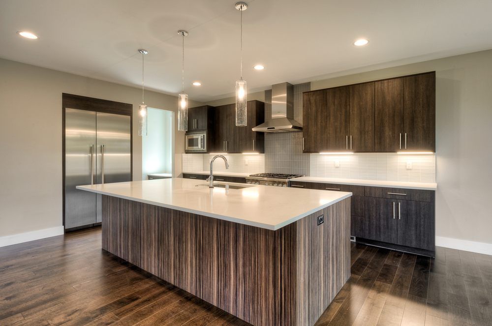 A kitchen with a large island and stainless steel appliances