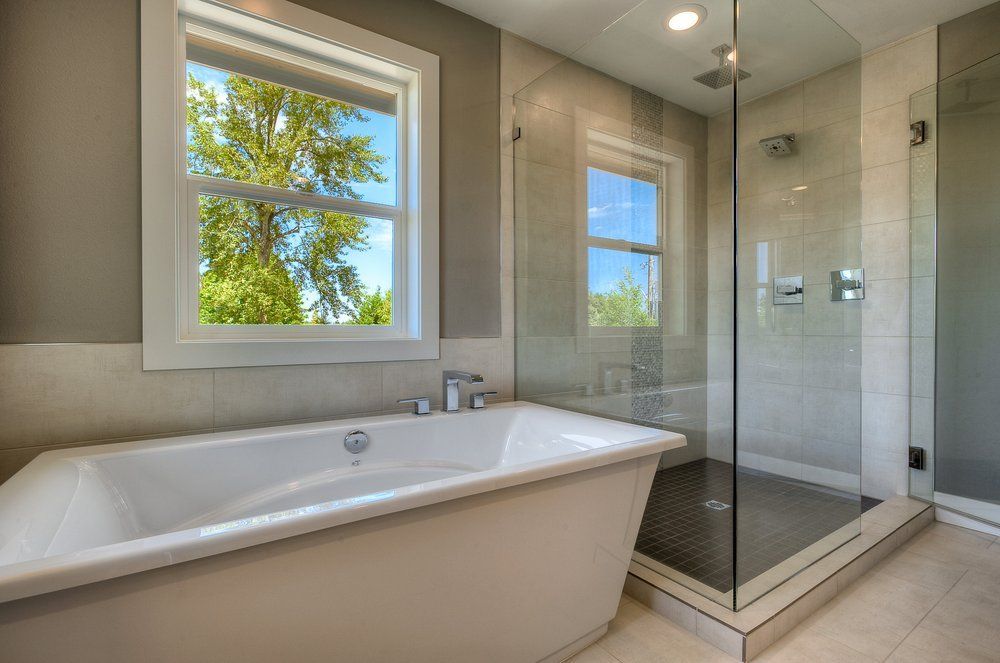 A bathroom with a tub and a walk in shower.