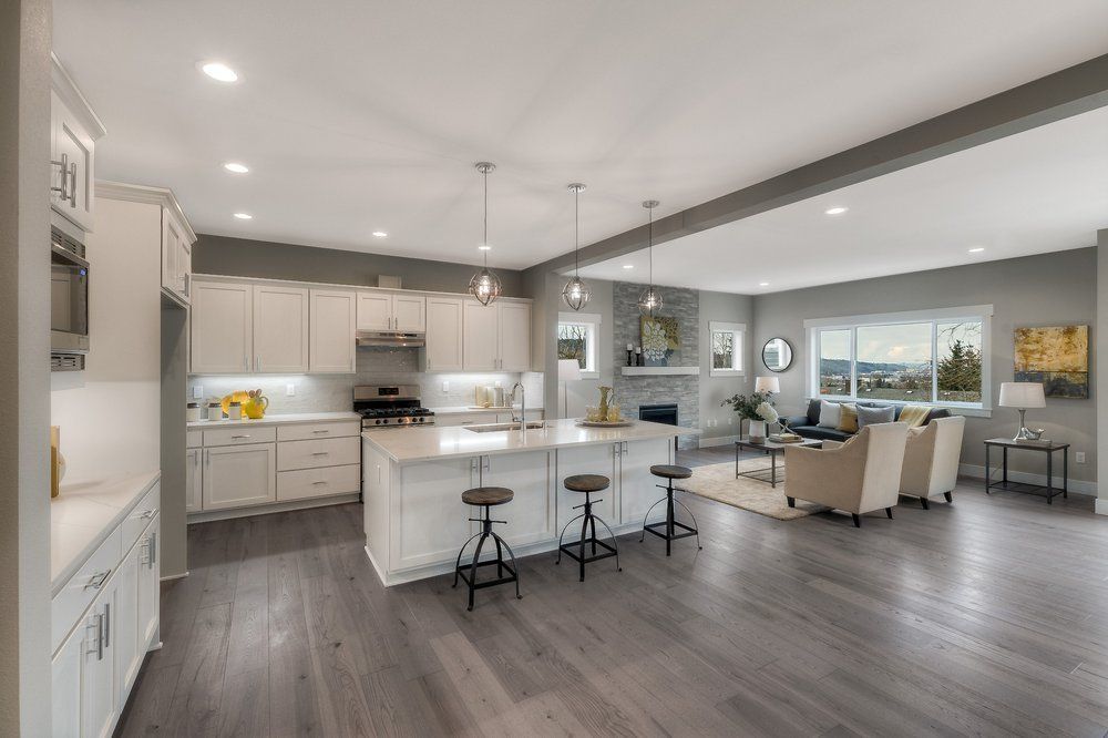 A kitchen , living room , and dining room in a model home.