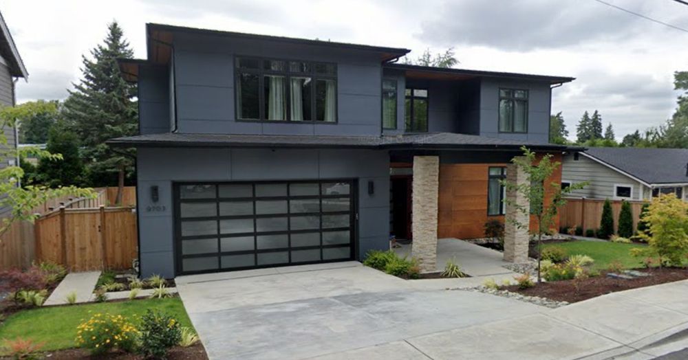 A modern house with a large garage door and a lot of windows.