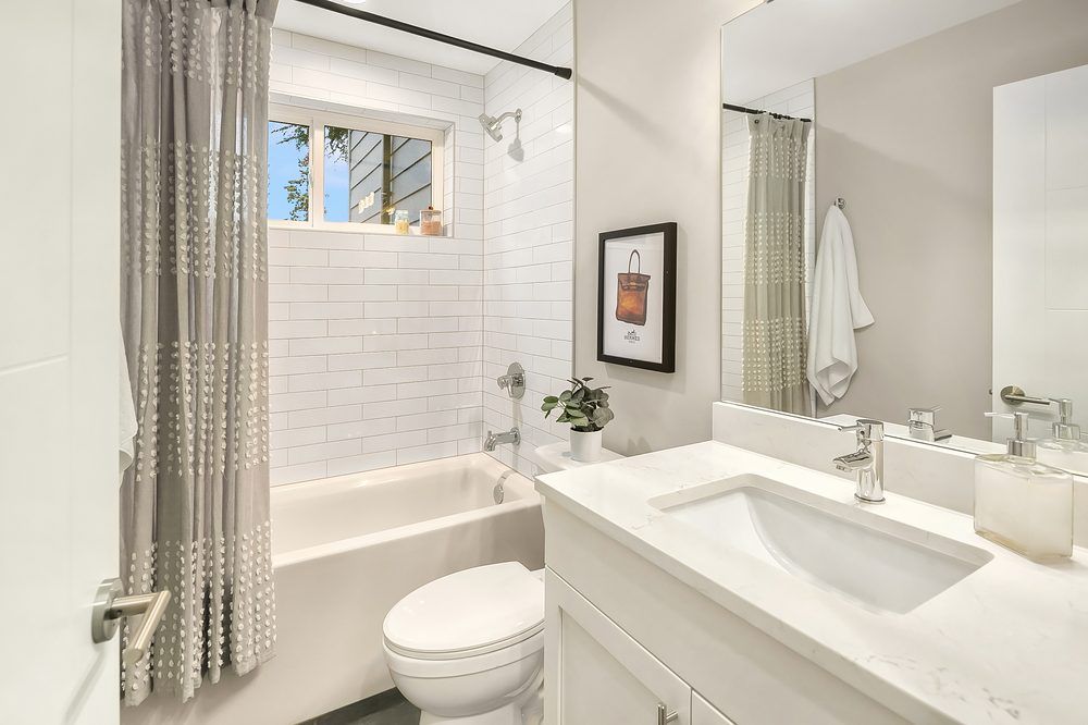 A bathroom with a toilet , sink and bathtub.