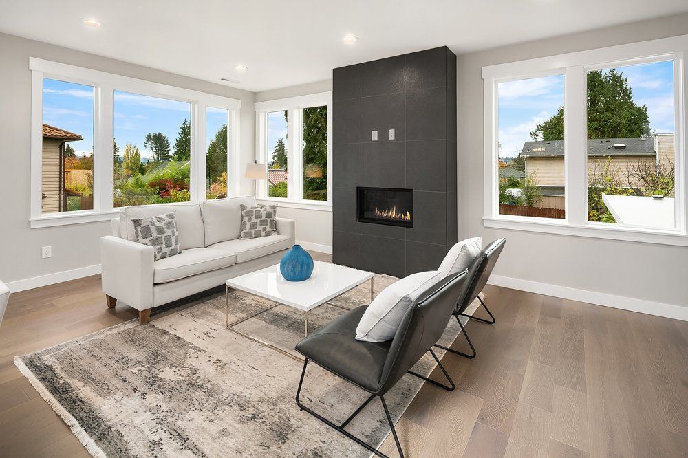A living room with a couch , chairs , coffee table and fireplace.