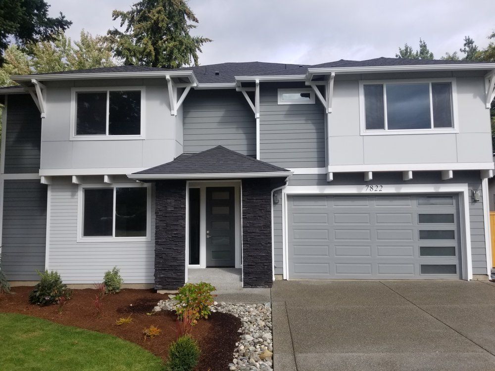 A gray house with a black garage door