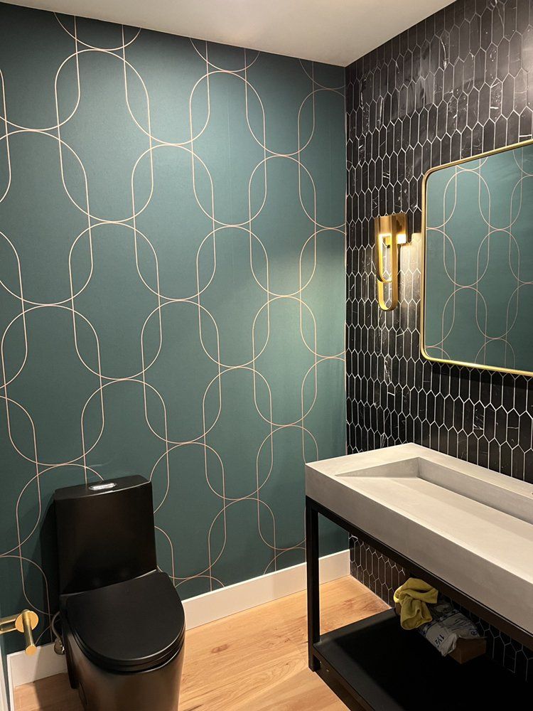 A bathroom with a toilet , sink and mirror.