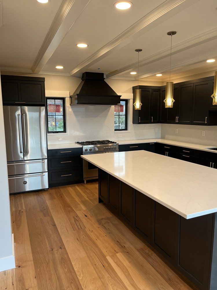 A kitchen with black cabinets and stainless steel appliances