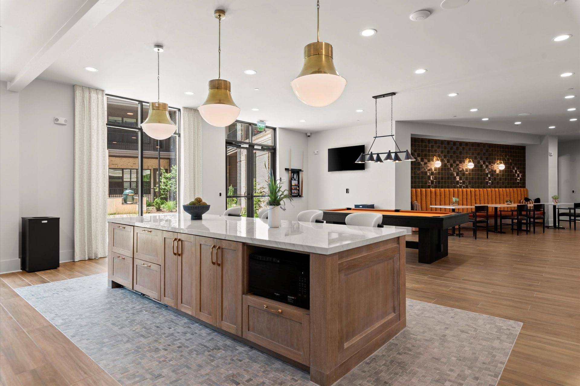 Spacious kitchen island with gold pendant lights in a modern communal space at EVOQ Marietta.