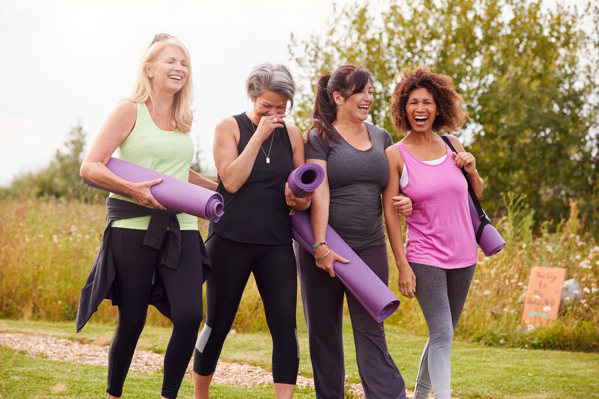 Group of women walking outdoors with yoga mats at EVOQ East Cobb