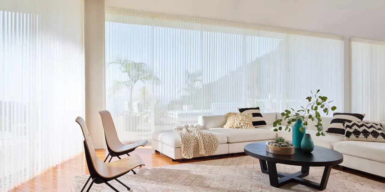 A living room with a couch , chairs , coffee table and blinds.