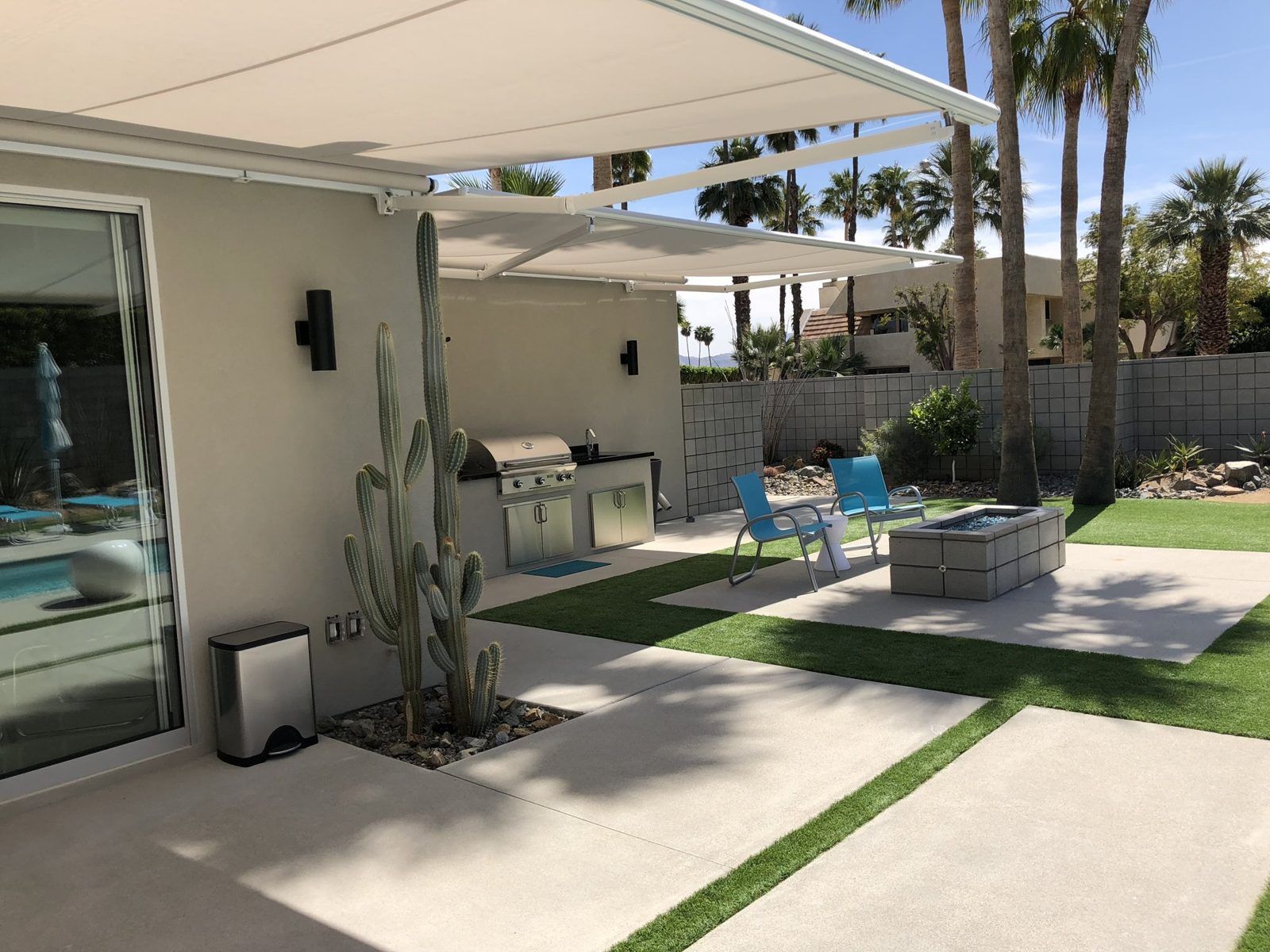 Retractable awning extended over a desert-modern patio with cactus landscaping