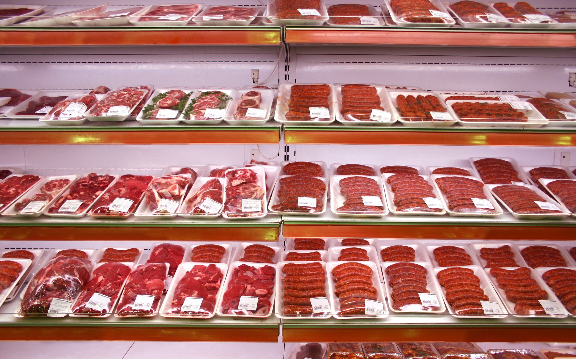 Neatly packaged cuts of raw meat displayed in refrigerated supermarket trays