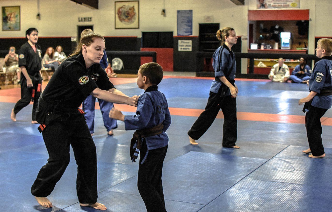 A group of people are practicing martial arts in a gym
