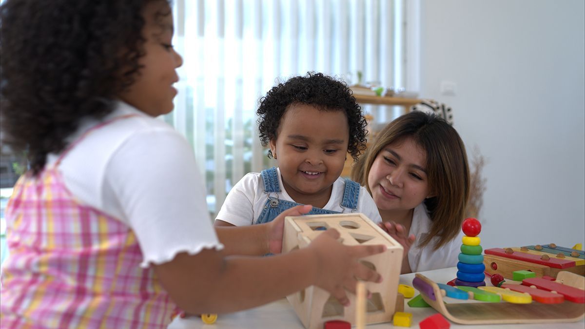 A group of children are playing with wooden toys at a table.