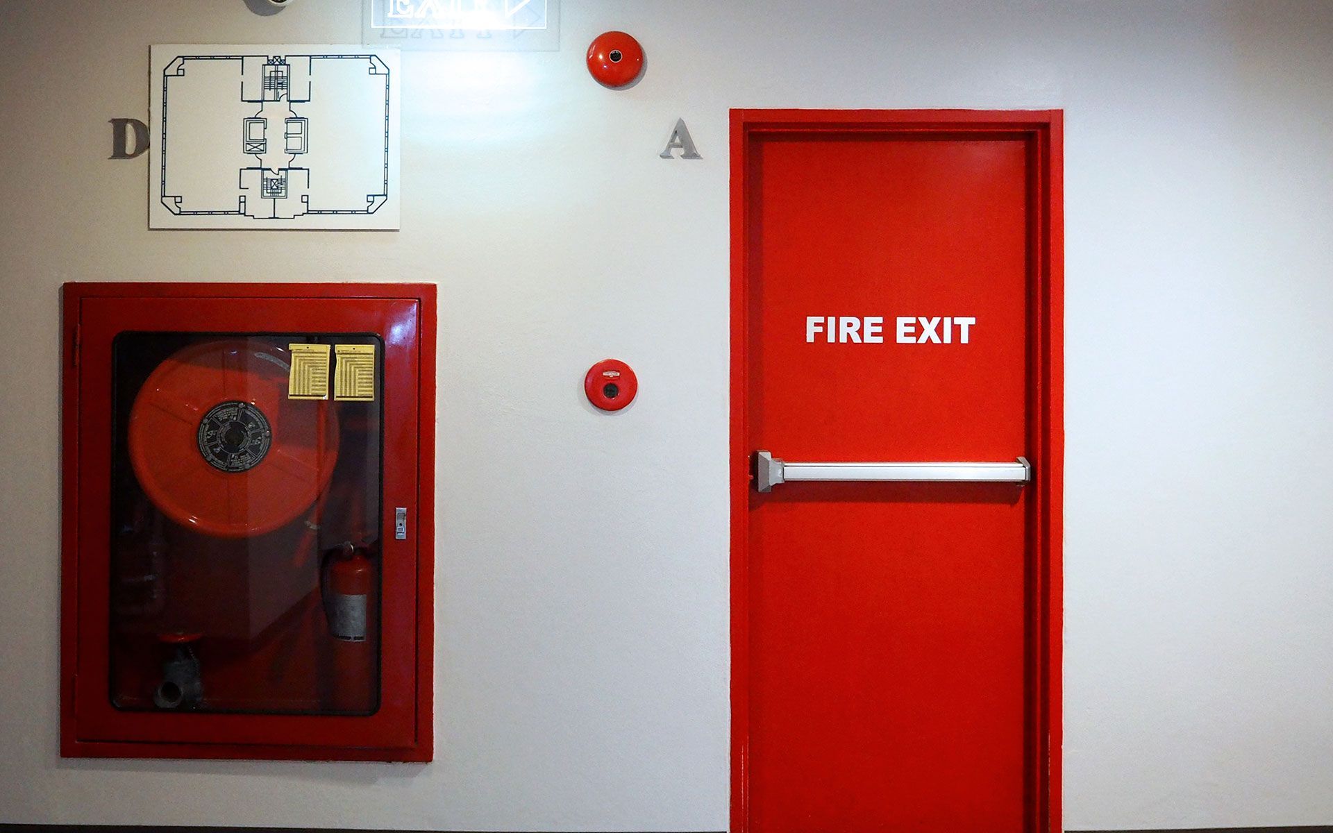 A red fire extinguisher sign is on a white wall.