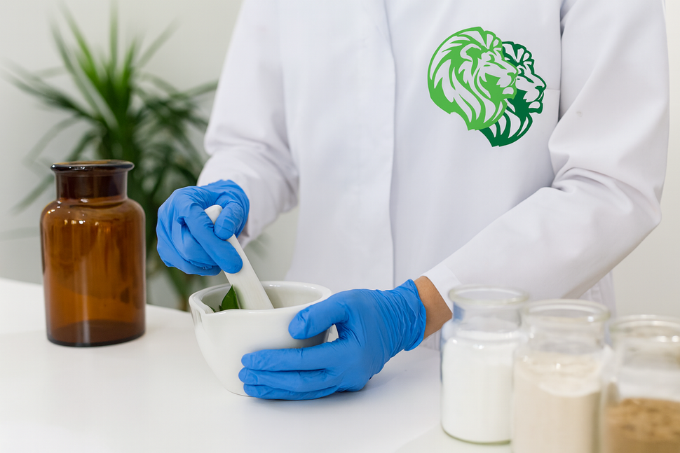 Una persona con i guanti mescola la panna in una ciotola accanto a dei barattoli e a una bottiglia marrone in un ambiente simile a un laboratorio.