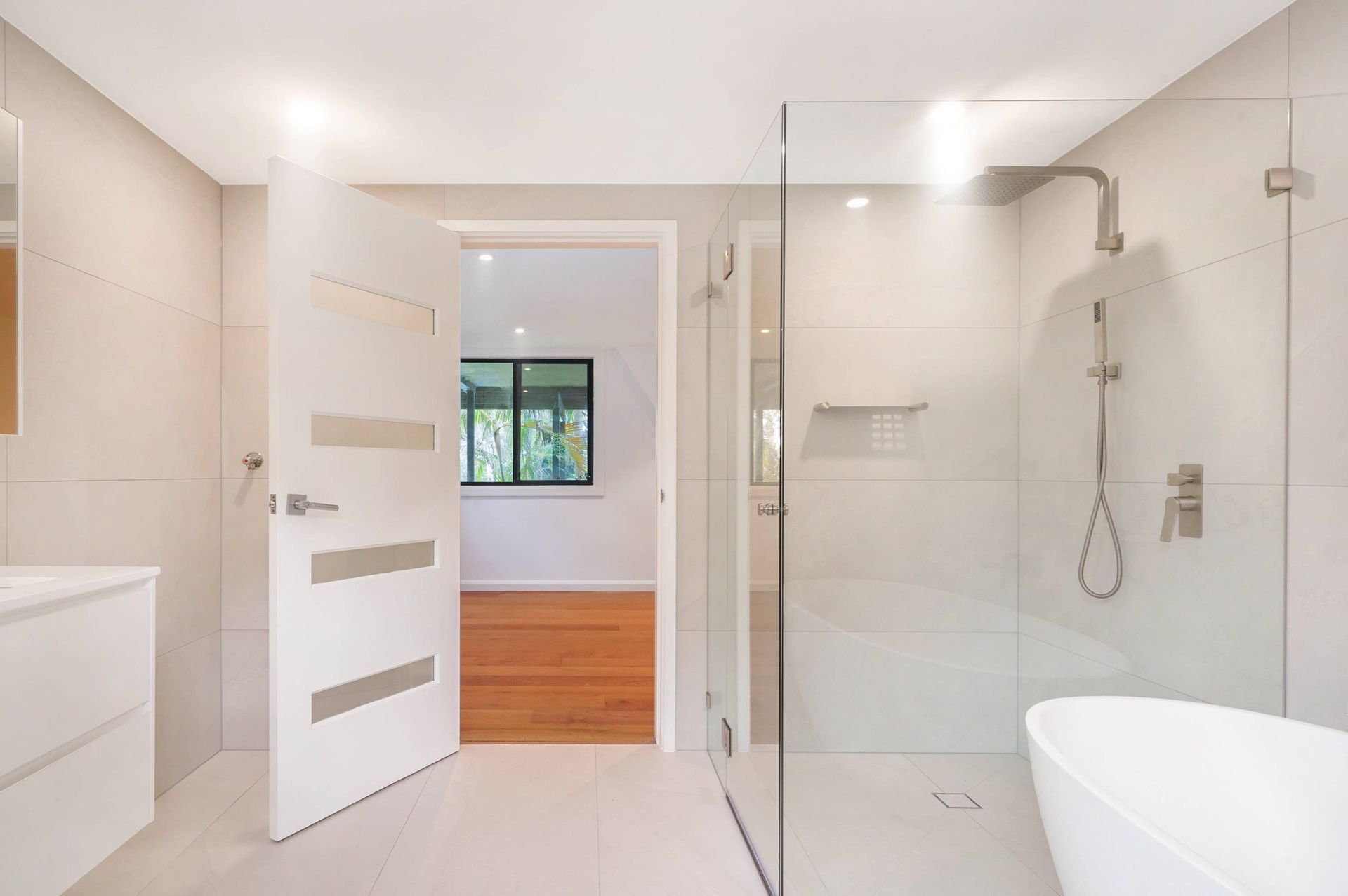 A well-renovated small bathroom with a glass shower section