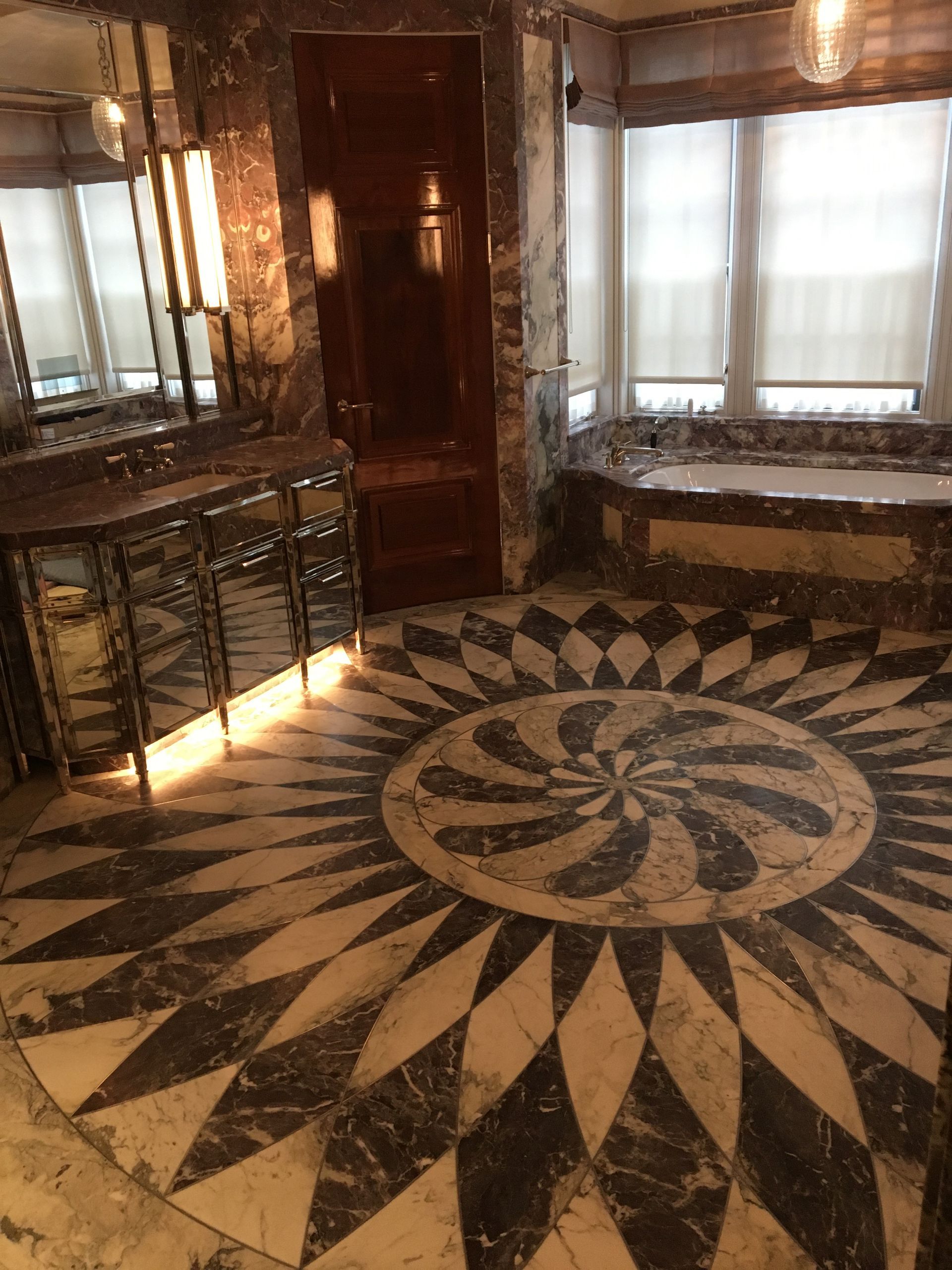 A bathroom with marble walls and a bathtub