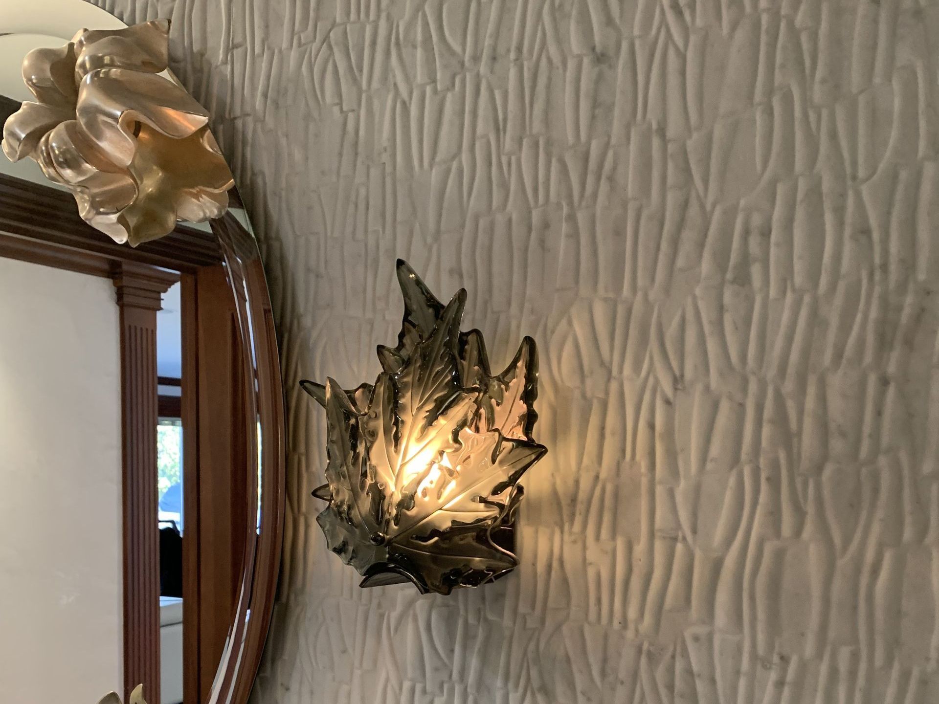 A wall with a lamp and a mirror on it