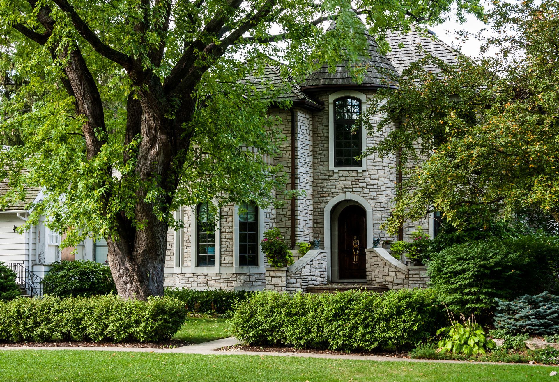 A large stone house with a large tree in front of it.