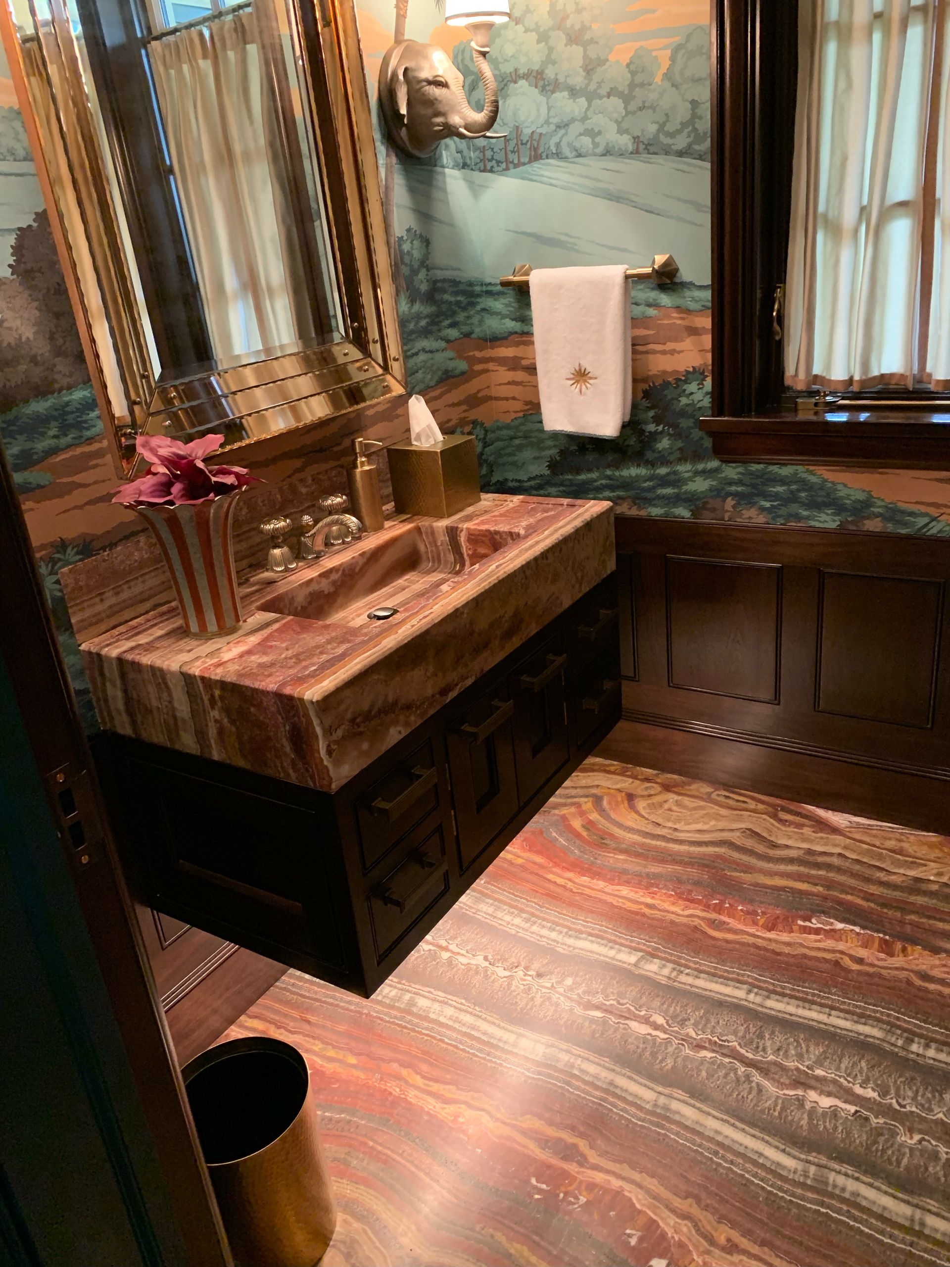 A bathroom with a sink , mirror , and towel rack.