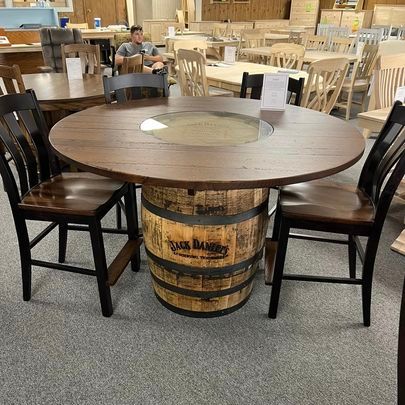 A man is sitting at a table with a barrel in the middle of it.