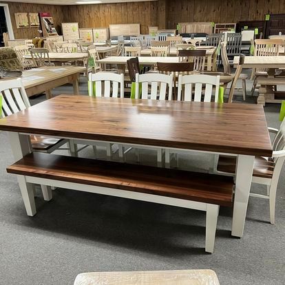 A wooden table with a bench and chairs in a room.