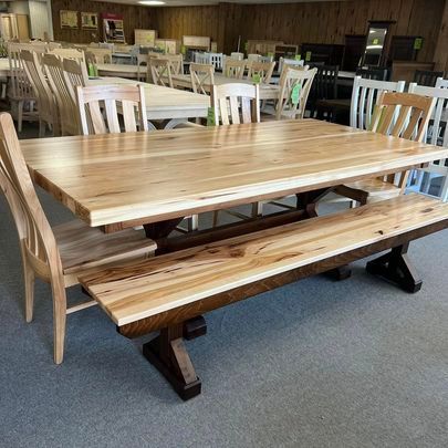 A wooden table with a bench and chairs in a room.