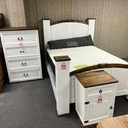 A bedroom with a bed , nightstand , dresser and mattress.