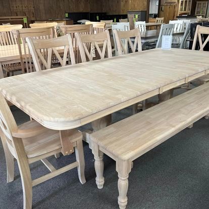 A wooden table with chairs and a bench in a room.