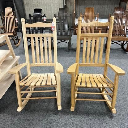 Two wooden rocking chairs are sitting next to each other in a room.