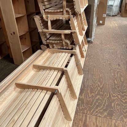 A bunch of wooden chairs are stacked on top of each other