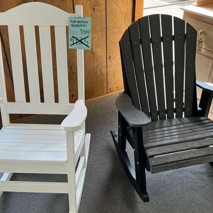 A white rocking chair and a black rocking chair are sitting next to each other.