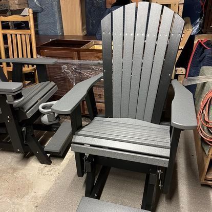 A gray and black adirondack chair is sitting in a room.