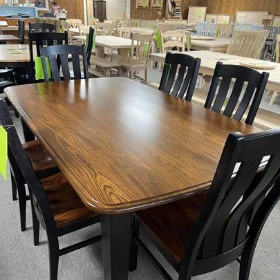 A wooden table with black chairs in a room.